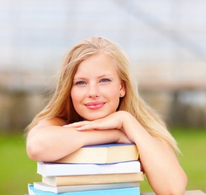 cute-young-woman-lying-on-a-stack-of-books-xs